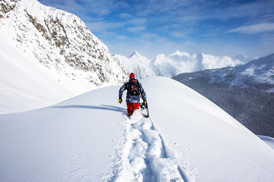 American professional snowboarder Travis Rice wades through snow up to his thighs 